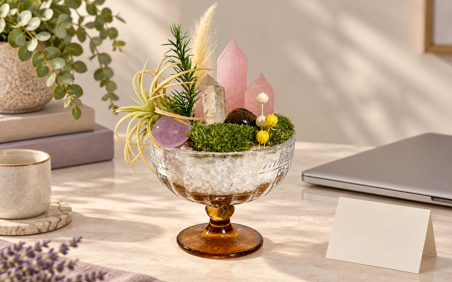 A crystal garden beside a closed laptop and blank note card.
